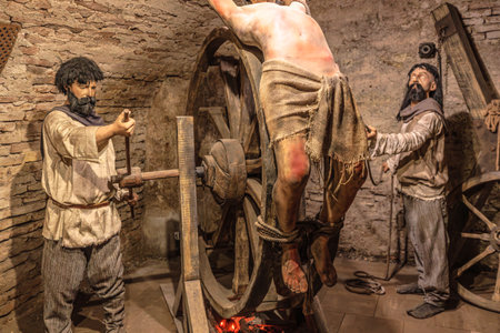 Transylvania, Romania - Oct 8, 2025: Wax figures depicting a brutal medieval torture scene using a breaking wheel, a historical reenactment in a castle museum of Corvin Castle museumのeditorial素材