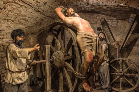 Transylvania, Romania - Oct 8, 2025: Depicting historical torture methods in a museum exhibition, showing suffering figures and ancient tools like breaking wheels of Corvin Castle museumのeditorial素材