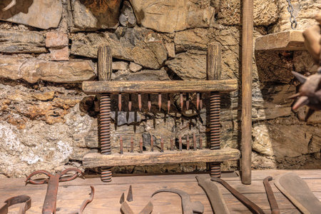 Transylvania, Romania - Oct 8, 2025: Torture instruments displayed in a historical museum, reflecting a dark past within the Walls of Corvin Castle in Hunedoara, Romaniaのeditorial素材