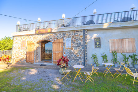 Martinique, French Antilles - Dec 26, 2025: Hardy distillery terrace offering outdoor seating and lounge areas under pergolas, enjoying the Caribbean landscapeのeditorial素材