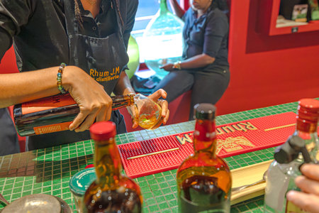 Martinique, French Antilles - Dec 27, 2025: Person pouring aged Rhum JM Agricole rum from a bottle into a tasting glass at the distillerys bar in Martinique, French Antillesのeditorial素材
