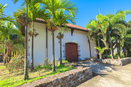 Martinique, French Antilles, - Dec 20, 2025: Habitation La Salle in Martinique with colonial buildings with virgin mary statue, lush tropical gardens, iconic palm trees, over rhum agricole distilleryのeditorial素材