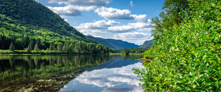 Awesome view of a lake and some verdant hills in Jacques Cartier National Park, Quebec province, Canada. Everything is green and mindblowing over here during summerの写真素材