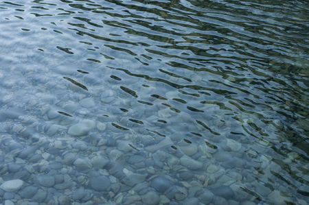 Surface of a river and pebblesの写真素材