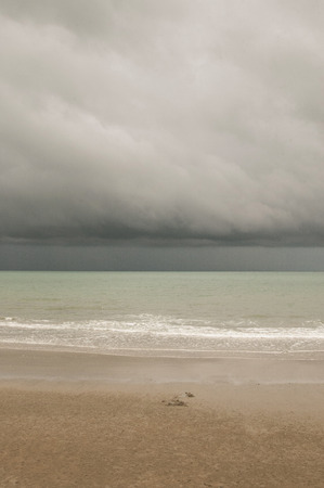 Clouds above the sea coming to the beachの写真素材