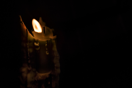 Close-up of a burning candle in a low-key imageの写真素材