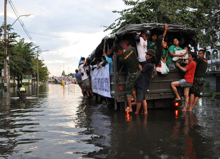 People are commuting in an army truck in a flooded street in Bangkok, Thailand, in October 2011のeditorial素材