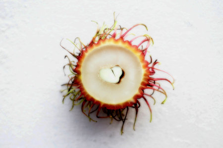 Half cut rambutan on a white surface
