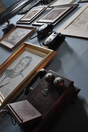Vintage telephones and framed drawings on a wall in Bangkok, Thailand.