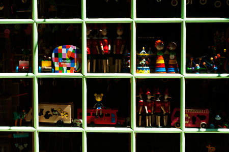 Vintage wooden toys displayed in a shop window in PÃ©zenas, France.のeditorial素材