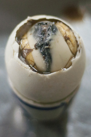 Duck embryo egg in a ceramic cup.の写真素材
