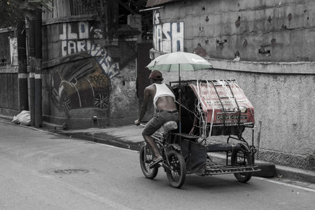 Rickshaw driver rides away in an empty street of Manila, the Philippines