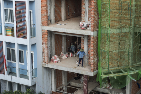 Workers are setting the electricty up in the wall of a bricks building in Ho Chi Minh City, Vietnam