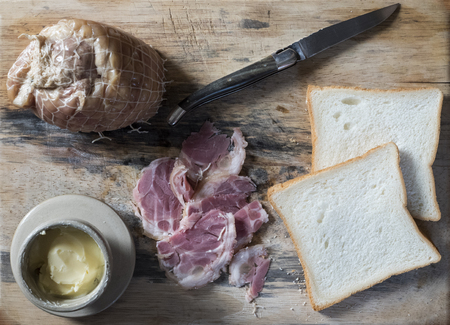 Vietnamese smoked pork, butter in pot, French traditional knife, and bread on a wooden board.の写真素材