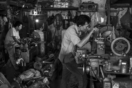 Indonesian workers operate their machines in an old workshop in Jakarta, Indonesia.のeditorial素材