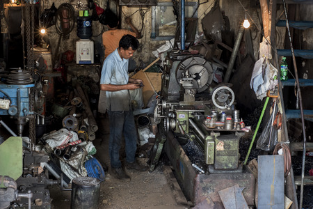 Indonesian worker operates his machine in an old workshop in Jakarta, Indonesia.のeditorial素材