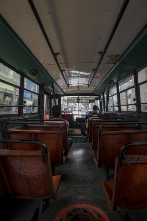 Indonesian passengers commute in an old empty bus in Jakarta, Indonesiaのeditorial素材