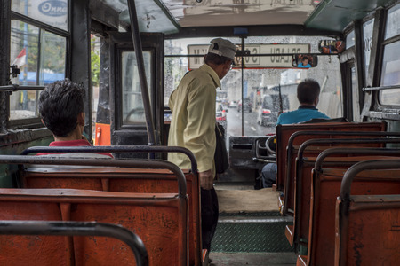 Indonesian passengers commute in an old empty bus in Jakarta, Indonesiaのeditorial素材
