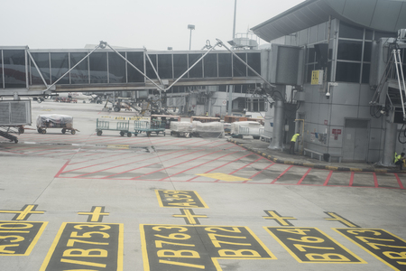 Bags are getting loaded before a flight at Kuala Lumpur International Airport in Malaysia.のeditorial素材