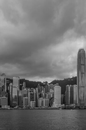 Large dark clouds gather above Hong Kong island, seen from Kowloon at Victoria Bayのeditorial素材