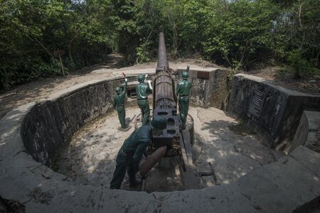 Mannequins of soldiers manipulating a large cannon at Cannon Fort in Cat Ba, Vietnamの写真素材