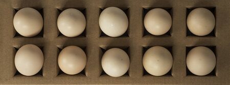 Top view of small chicken eggs in a cardboard boxの写真素材