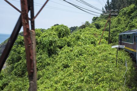 Train passes the sea, the hills, and jungle at the Hai Van Pass between Hue and Da Nang in Central Vietnamの写真素材