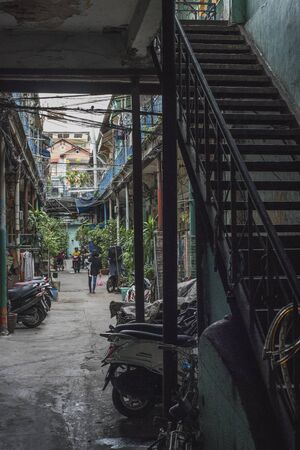 Local inhabitants enjoy a quiet moment in the old alley of Hao Si Phuong in Ho Chi Minh Cityの写真素材