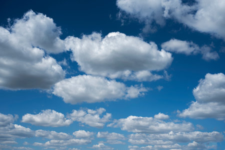 Blue sky with fluffy clouds in the Spring viewed from the ground.