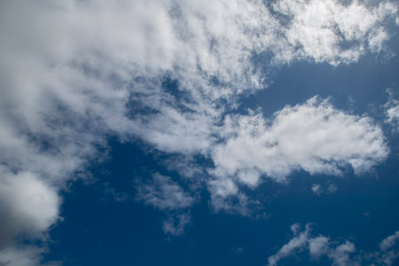 Blue sky with fluffy clouds in the Spring viewed from the ground.
