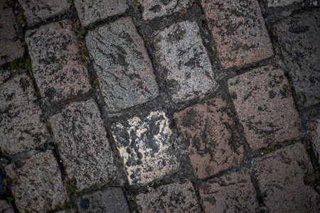 Closeup top view of cobblestones of different colors and textures from a medieval street in the French town of Angouleme.の写真素材