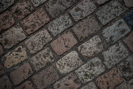 Closeup top view of cobblestones of different colors and textures from a medieval street in the French town of Angouleme.の写真素材