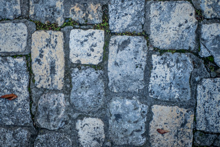 Closeup top view of cobblestones of different colors and textures from a medieval street in the French town of Angouleme.の写真素材