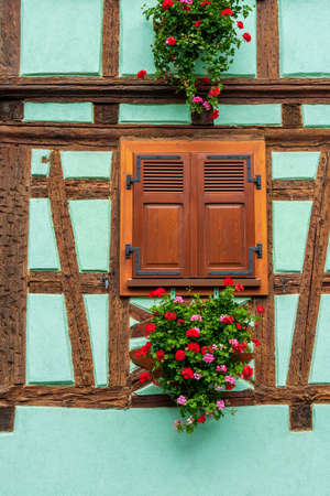 Window decorating with flowers on old timber frame house, France.の写真素材