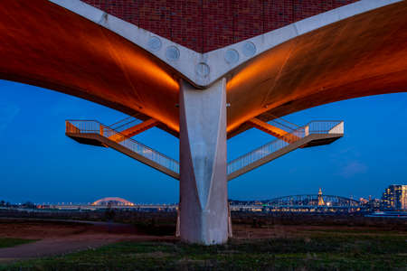 The De Oversteek bridge in the Dutch city of Nijmegen is illuminated in the evening.の写真素材