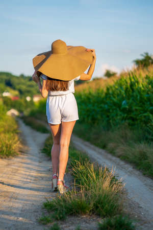 Young beautiful woman with summer hat in the corn field.の写真素材