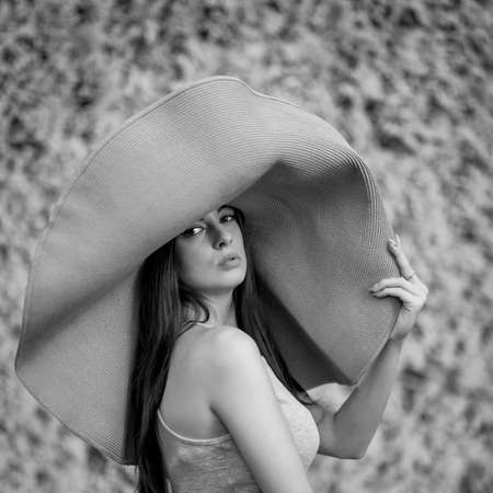 Young beautiful woman with big summer hatの写真素材