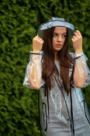 Young beautiful woman in hooded raincoat on rainy dayの写真素材