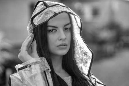 Young beautiful woman in hooded raincoat on rainy dayの写真素材