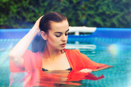 Portrait of a beautiful woman in the swimming pool.の写真素材