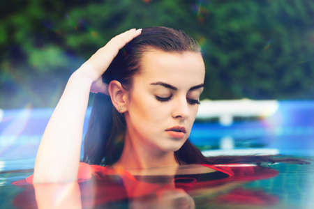 Portrait of a beautiful woman in the swimming pool.の写真素材