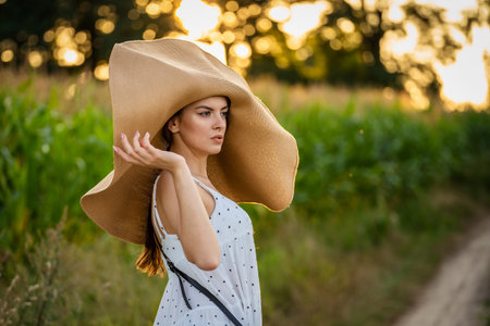 Young beautiful woman with summer hat in the corn field.の写真素材