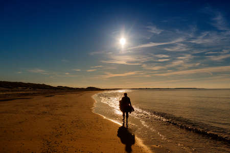 Woman walks on the North Sea beach, Netherlandsの写真素材