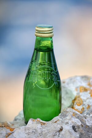 La Turbie, France - June 1, 2016: Perrier Sparkling Natural Mineral Water. Closeup of a Perrier Glass Bottle in The Natureのeditorial素材