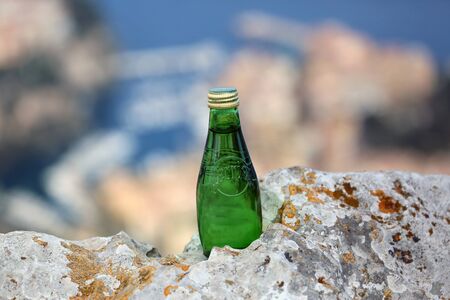 La Turbie, France - June 1, 2016: Perrier Sparkling Natural Mineral Water. Closeup of a Perrier Glass Bottle in The Natureのeditorial素材
