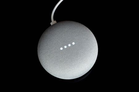 Paris, France - December 17 2018: Overhead View Of A Google Home Mini With Cable (Chalk Color), Black Background. Smart Speaker With The Google Assistant, Virtual Assistant Powered By Artificial Intelligenceのeditorial素材
