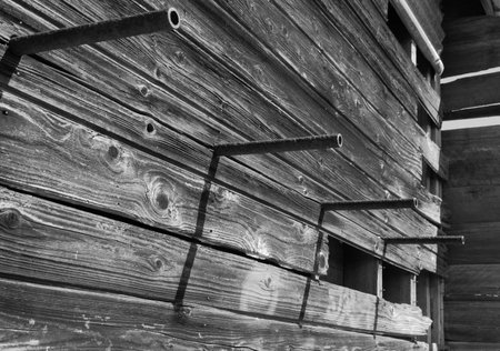 metal hanging rods on outside of delapidated home