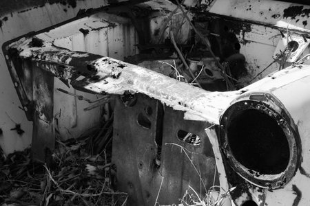 rusted out car body in abandoned shedの写真素材