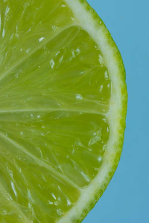 Lime slice closeup on blue backgroundの写真素材