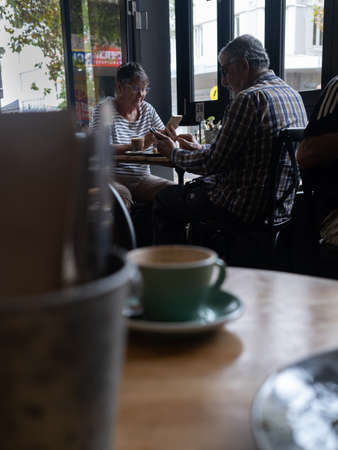 NEWCASTLE, NSW/AUSTRALIA  MARCH 17 2019: Elderly couple ignoring each other and staring at their phone screens, instead of talking to each other.のeditorial素材